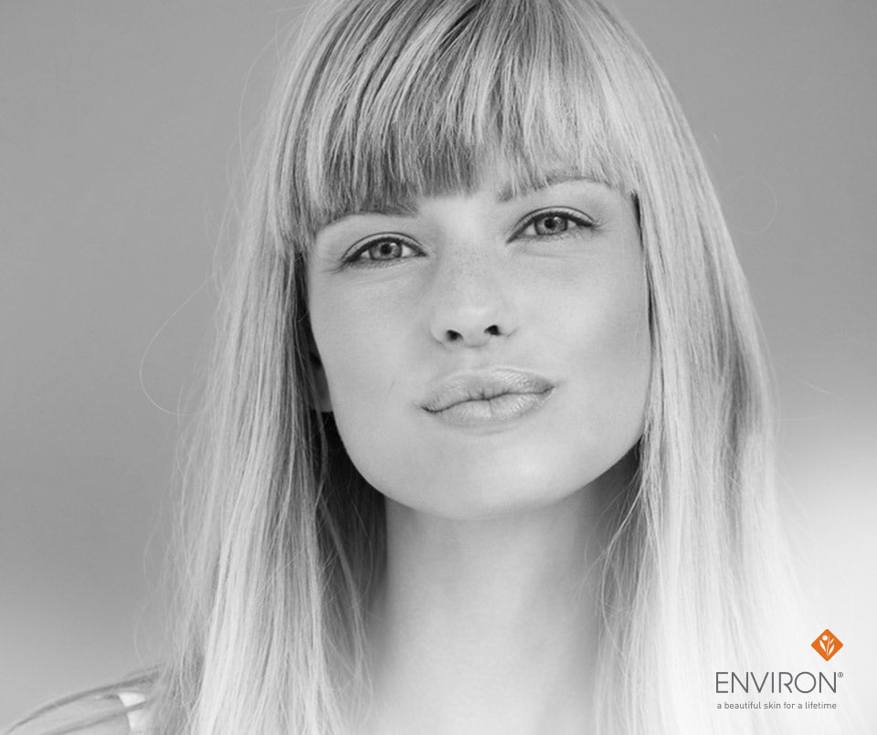 Black and white portrait of a woman with straight shoulder length blonde hair and bangs for youthful looking skin article