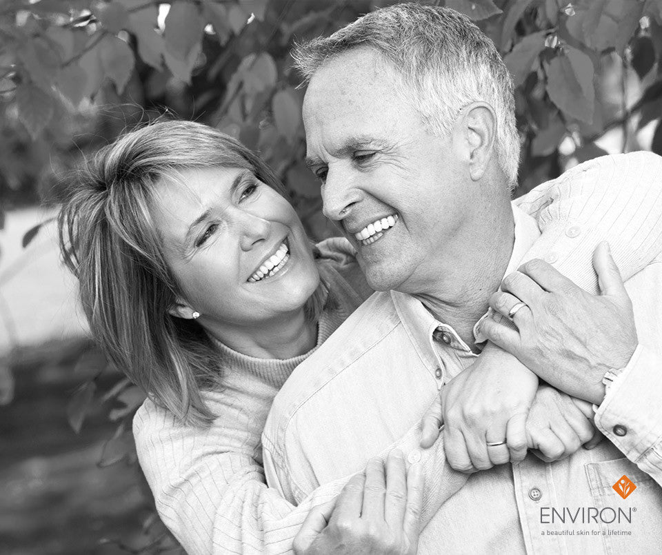 Black-and-white photograph of a smiling couple embracing outdoors illustrating benefits to aging happily