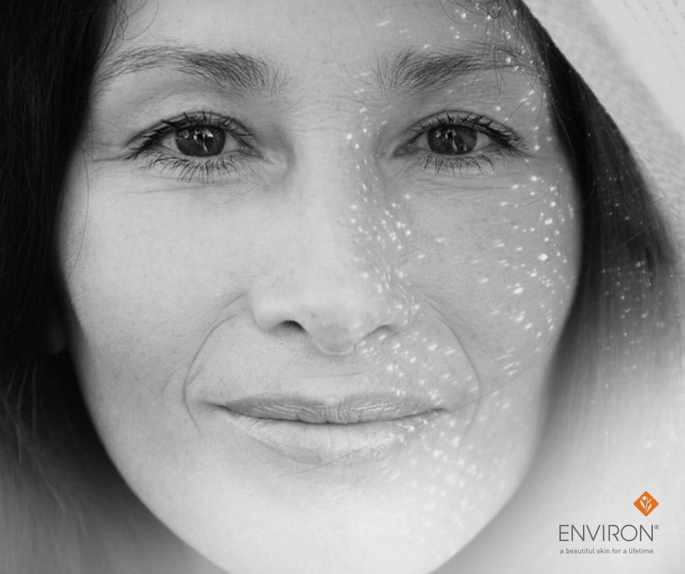 Black-and-white portrait of a woman with dark hair and eyes smiling gently wearing a light-colored hood in pump up the volume