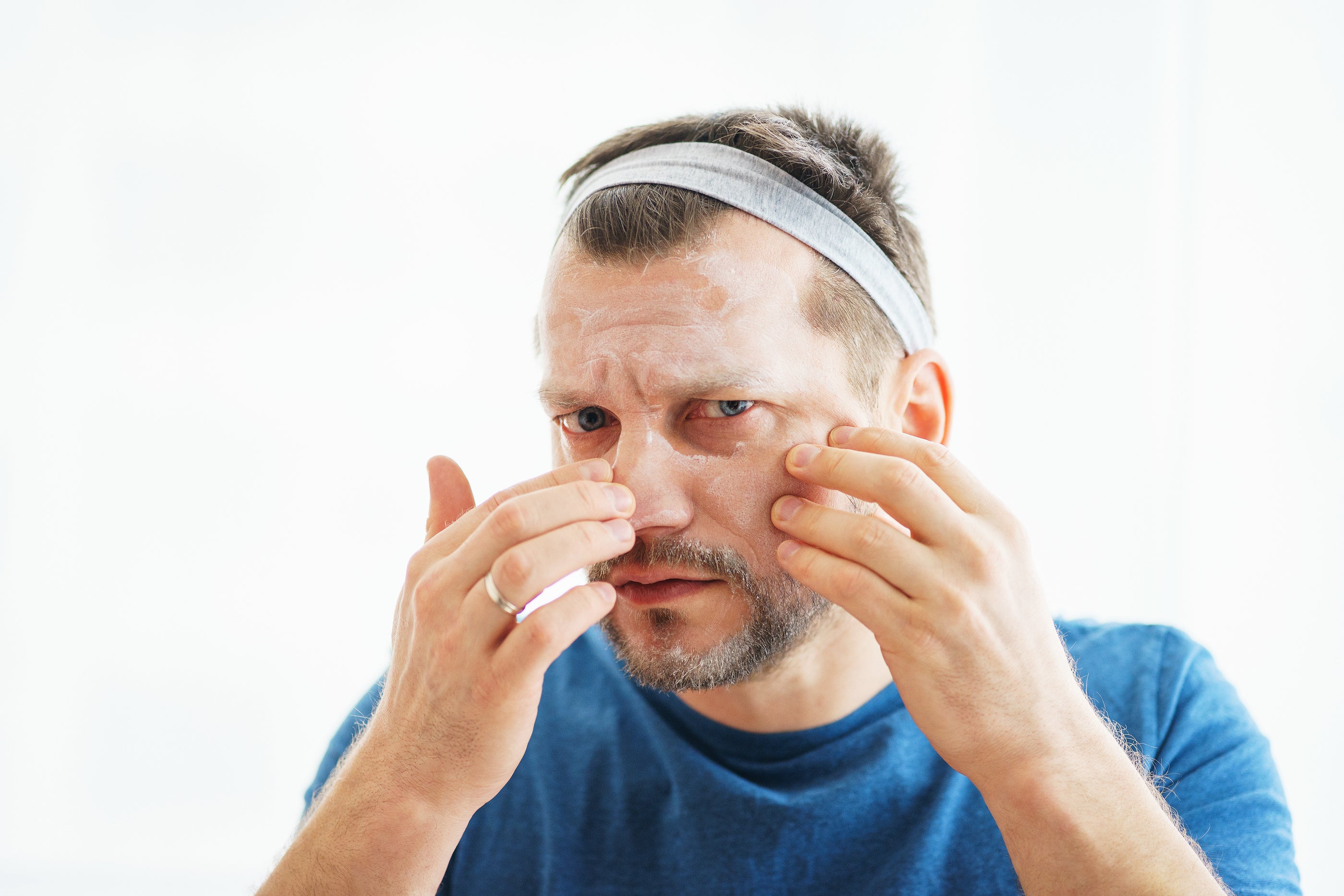 Man wearing a light gray fabric headband and blue t-shirt in an article titled Men have skin in the game