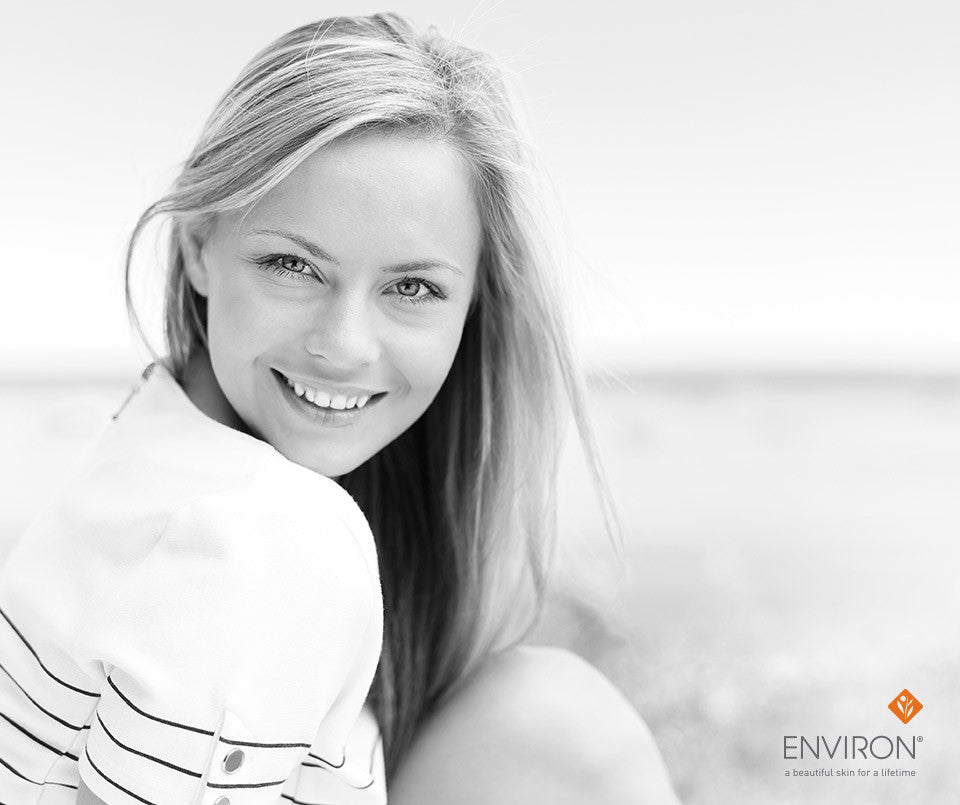 Black and white portrait of a smiling woman with long blonde hair wearing a white top with black stripes for beauty myths article