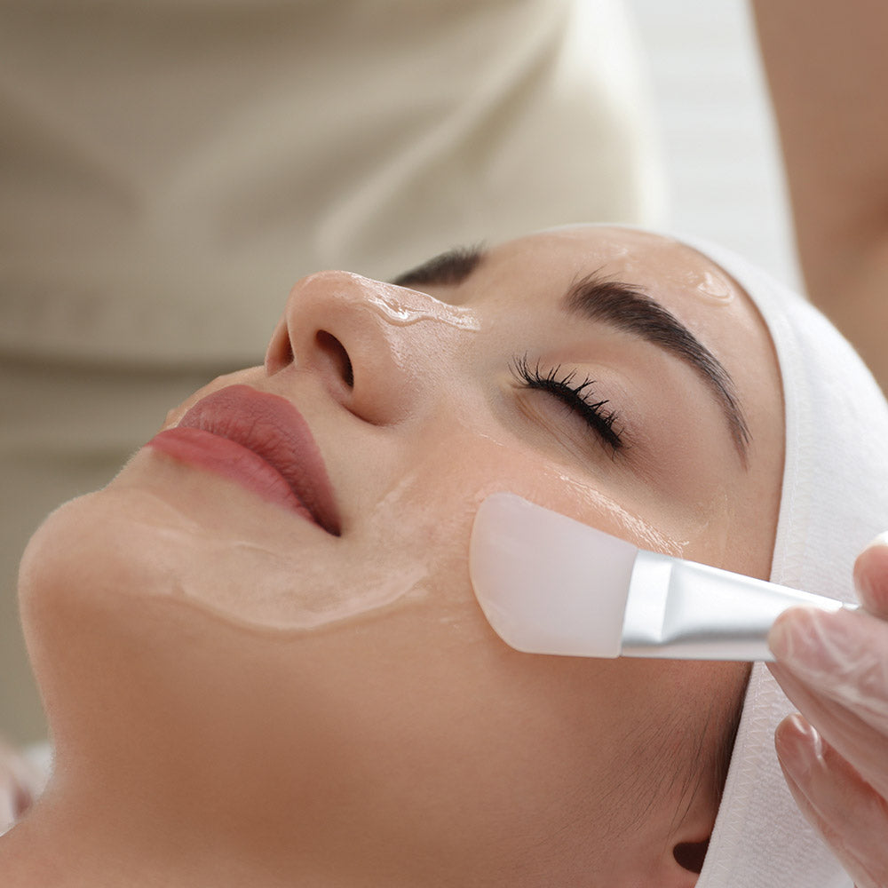 White plastic facial cleansing brush with smooth rounded head and sleek handle for chemical peel benefits