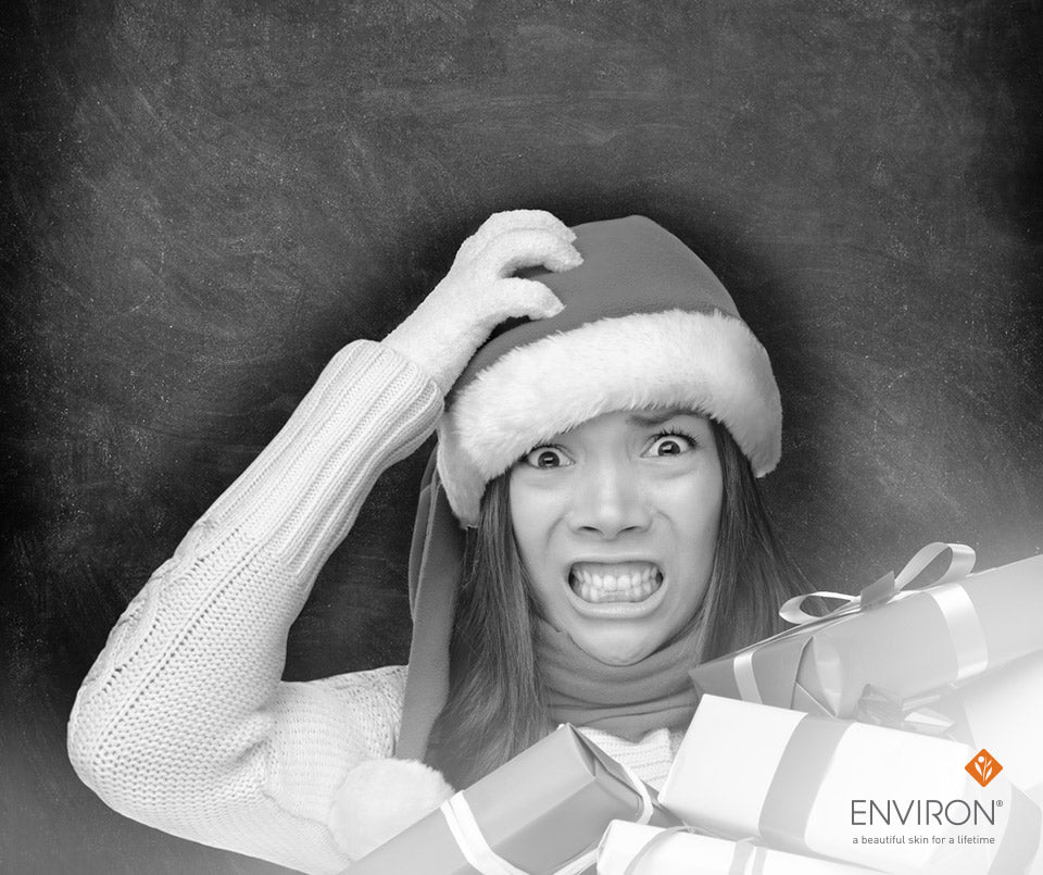 A woman wearing a red santa hat with white trim holding wrapped gifts to make the holidays happier and healthier.