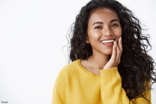 A model wearing a vibrant yellow long-sleeved knit sweater with a cozy texture and classic crew neckline