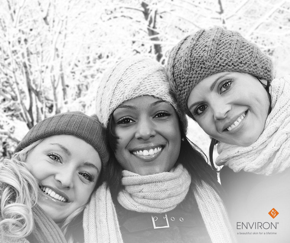Three women wearing knitted winter hats and scarves in bright colors promoting glowing winter skin care tips.
