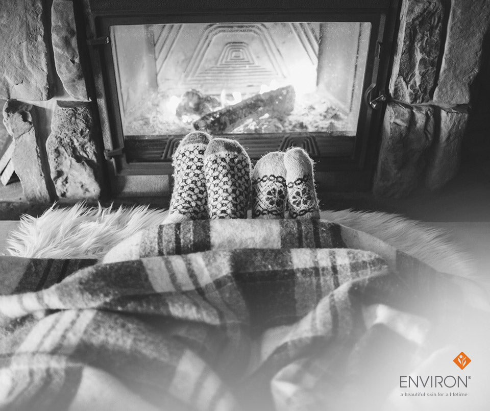 Knitted wool socks with intricate geometric and floral patterns displayed in cozy fireplace for winter skin renewal
