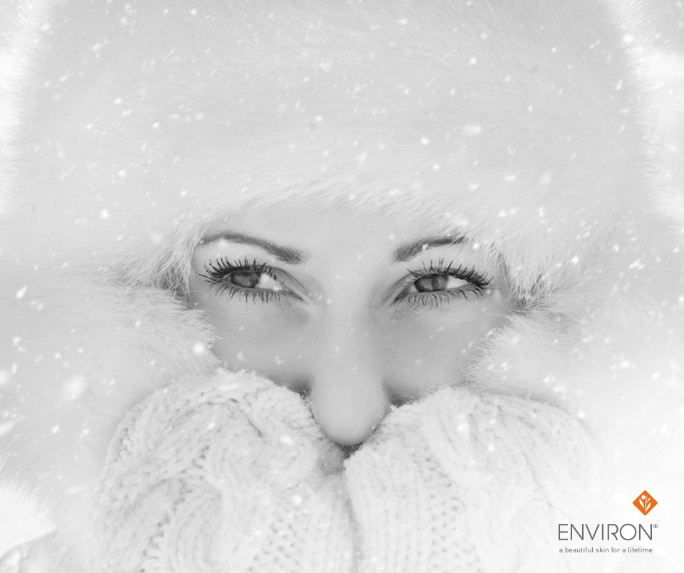 A woman wearing a fluffy white winter hat and matching knitted gloves for cold weather warmth.