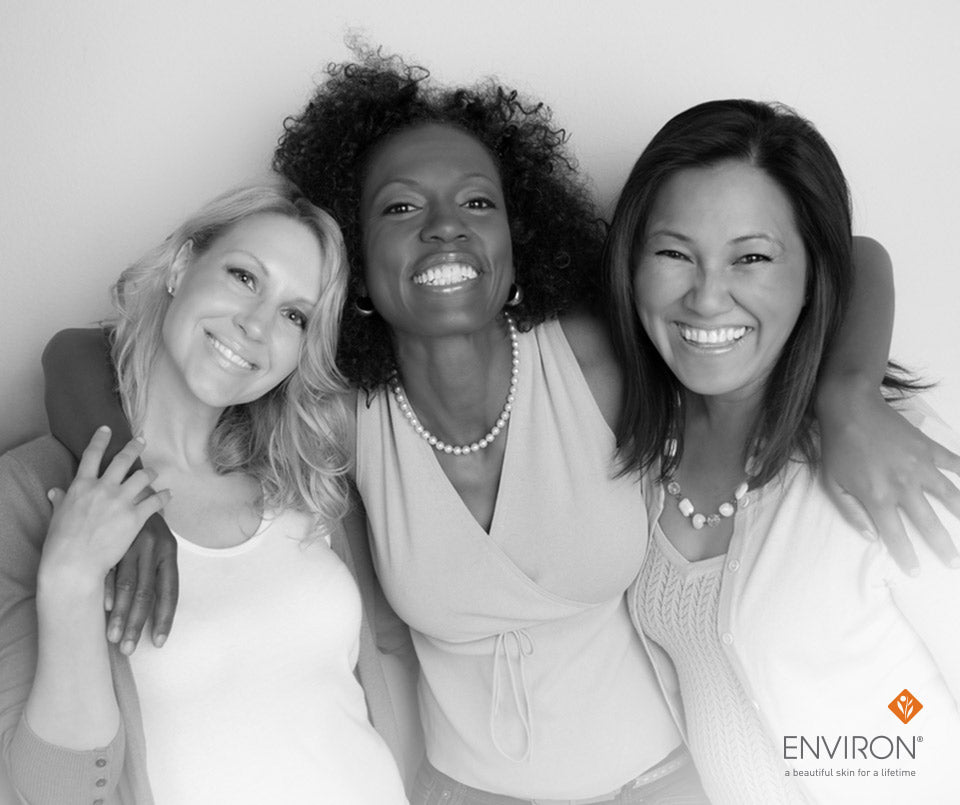 Black-and-white photograph of three smiling women posing closely together promoting steps to glowing skin care.