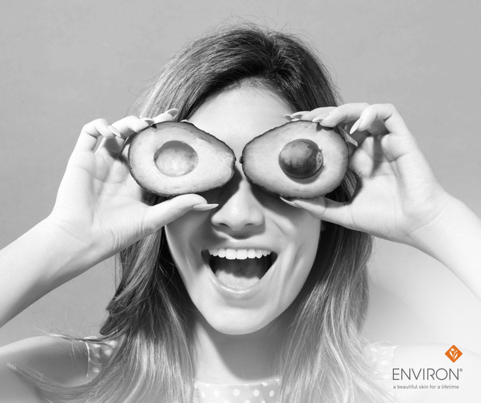 Half avocados used as playful green fruit eyewear in an article about the healthy skin diet and nutrition benefits