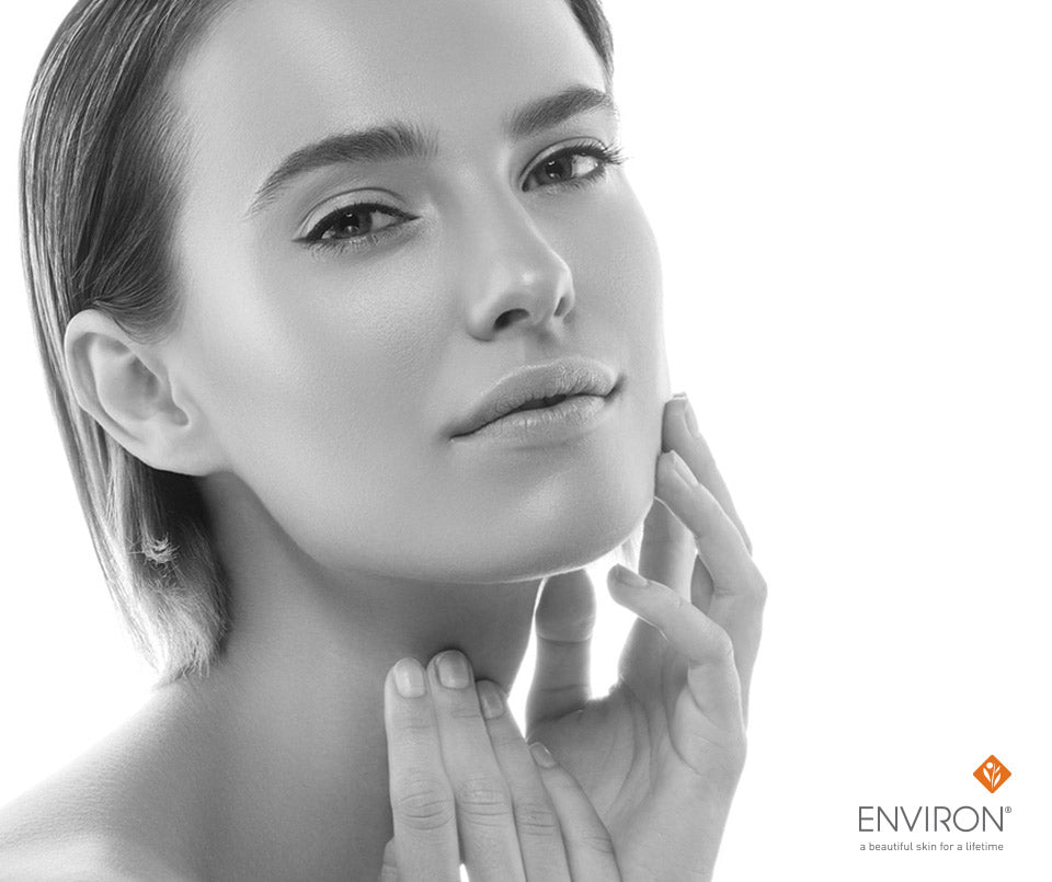 A woman with smooth radiant skin gently touching her face in a soft black and white portrait for smart skin care article