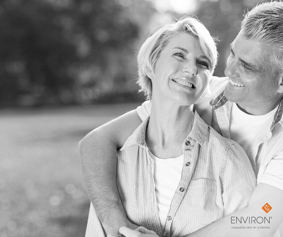 Black and white photograph of a smiling couple embracing outdoors for pump up the volume article