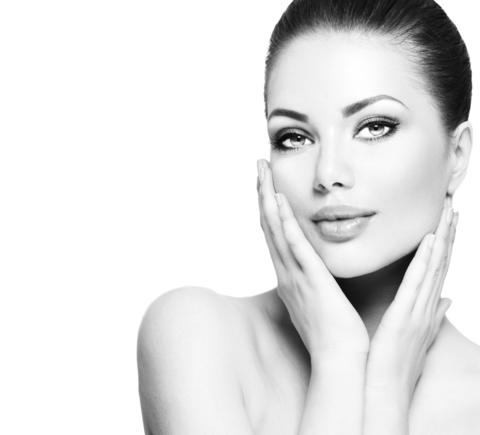 A woman with dark hair in a sleek updo and subtle makeup poses gracefully in an article about the essence of beauty