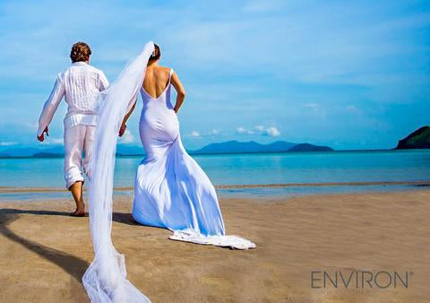A flowing light blue satin wedding gown with a deep back cut and lace trim perfect for wedding day skin care preparation