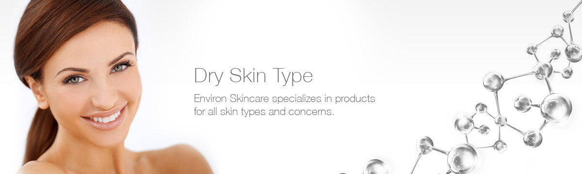 A woman with brown hair and blue eyes smiles wearing a white top against a clean background for dry skin.