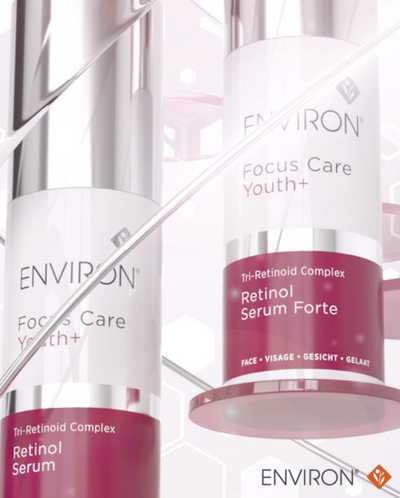 Two sleek, cylindrical environ skincare bottles with white labels and burgundy bands featuring silver caps.