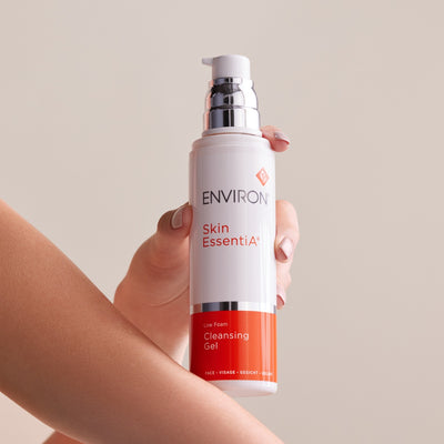 A sleek white and orange pump bottle of environ skin essentia low foam cleansing gel.
