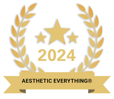 Gold laurel wreath emblem featuring three stars and the year 2024, with a ribbon banner reading ’aesthetic everything®’.