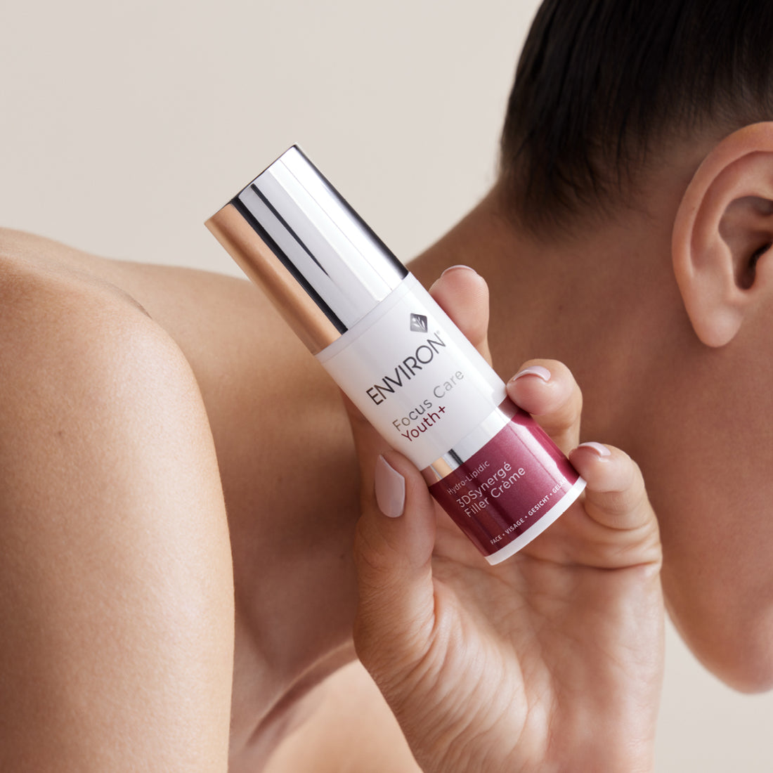 A sleek, cylindrical environ focus care youth+ 3d synergé filler creme bottle with a metallic silver cap and white label accented by deep burgundy text.