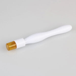 A white plastic dental applicator tool with an ergonomic textured grip and a translucent amber tip sits on a plain grey surface.