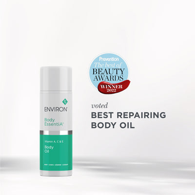 White and teal cylindrical bottle of environ body essentia+ body oil with silver band.