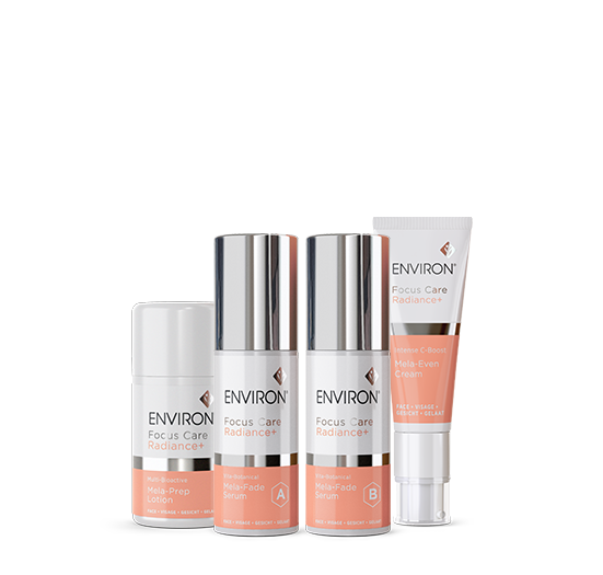 Four Environ Focus Care Radiance+ skincare products, including Mela-Prep Lotion, Mela-Fade Serums A and B, and Mela-Even Cream, stand neatly arranged against a white background.