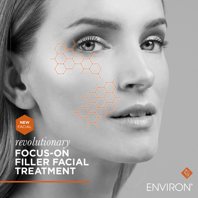 A woman’s face with orange hexagonal molecular patterns overlaid on her cheek and jawline, presented in a grayscale advertisement for environ’s revolutionary focus-on filler facial treatment.