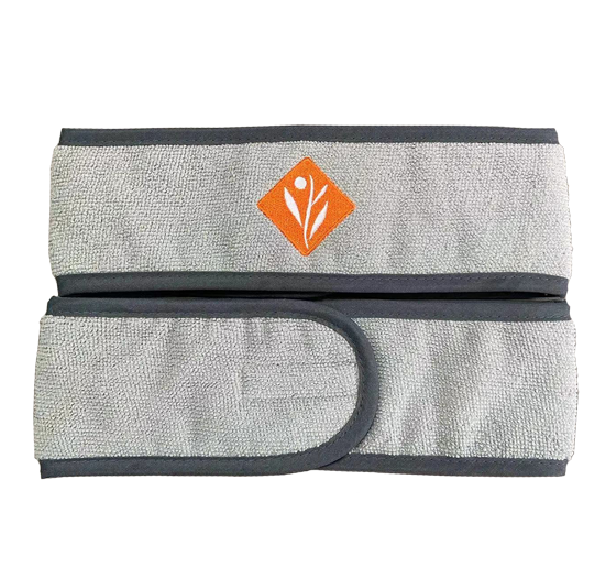 A plush gray microfiber makeup headband with an orange diamond logo secures hair with an adjustable hook-and-loop closure.