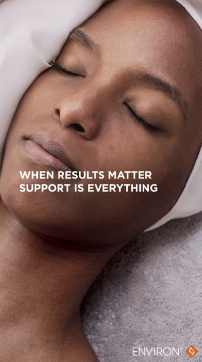 A woman with dark skin and closed eyes rests her head on a soft white towel, wrapped in serene calm.