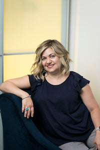 Woman wearing a navy blue ruffled short-sleeve top with striped pants