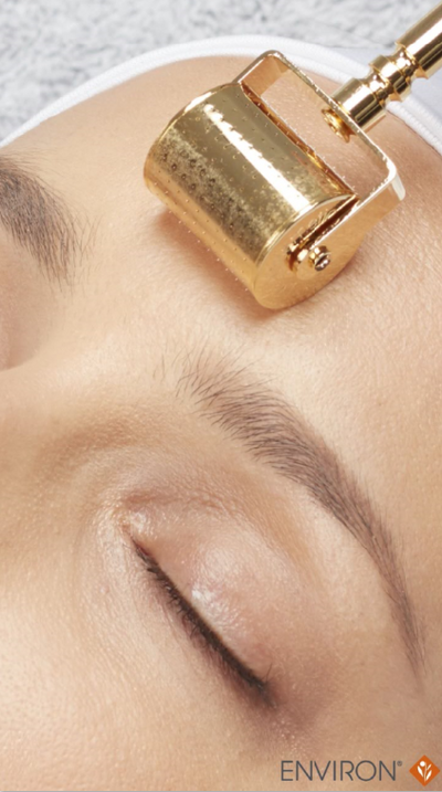 Gold-colored roller device with a metallic finish and cylindrical design, featuring a handle for manual operation.