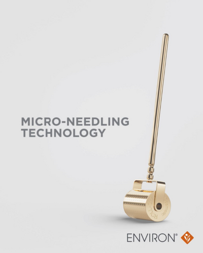 Gold-colored, cylindrical micro-needling roller with a sleek metallic finish and engraved branding.