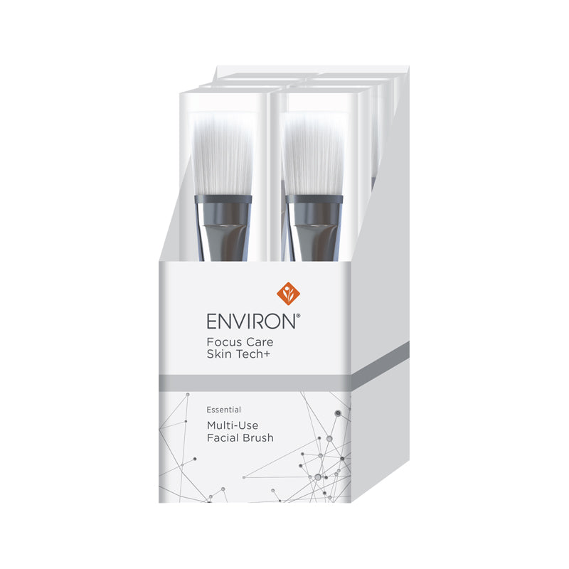 A white display box showcases several Environ Focus Care Skin Tech+ multi-use facial brushes featuring soft white bristles and silver ferrules.