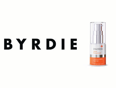 A sleek, transparent glass bottle with a silver pump and an orange label featuring the ’environ skin essentials’ branding.