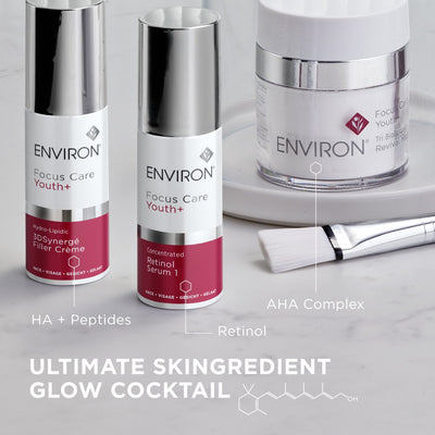 Two silver-topped, white-bodied environ focus care youth+ skincare bottles with magenta labels and a matching jar of aha complex serum.
