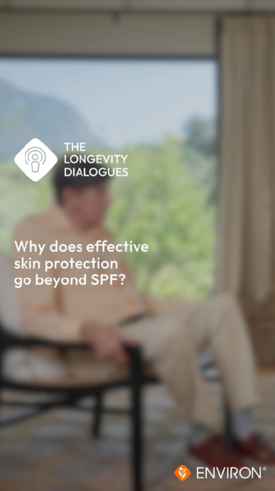 A man in a beige suit sits relaxed on a chair, with the text ’why does effective skin protection go beyond spf?’ displayed prominently over him.