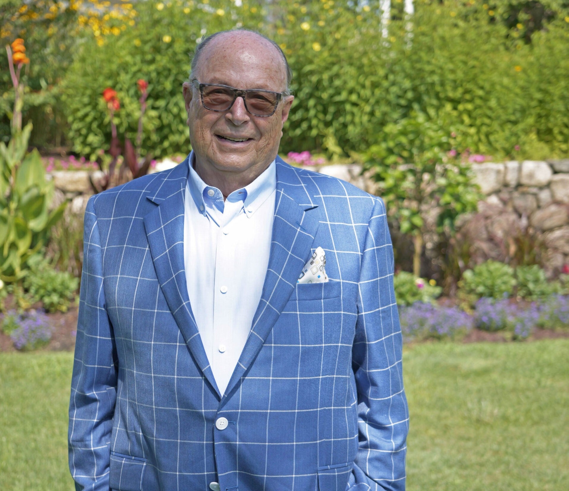 Blue checkered suit jacket with white buttons and a patterned pocket square.