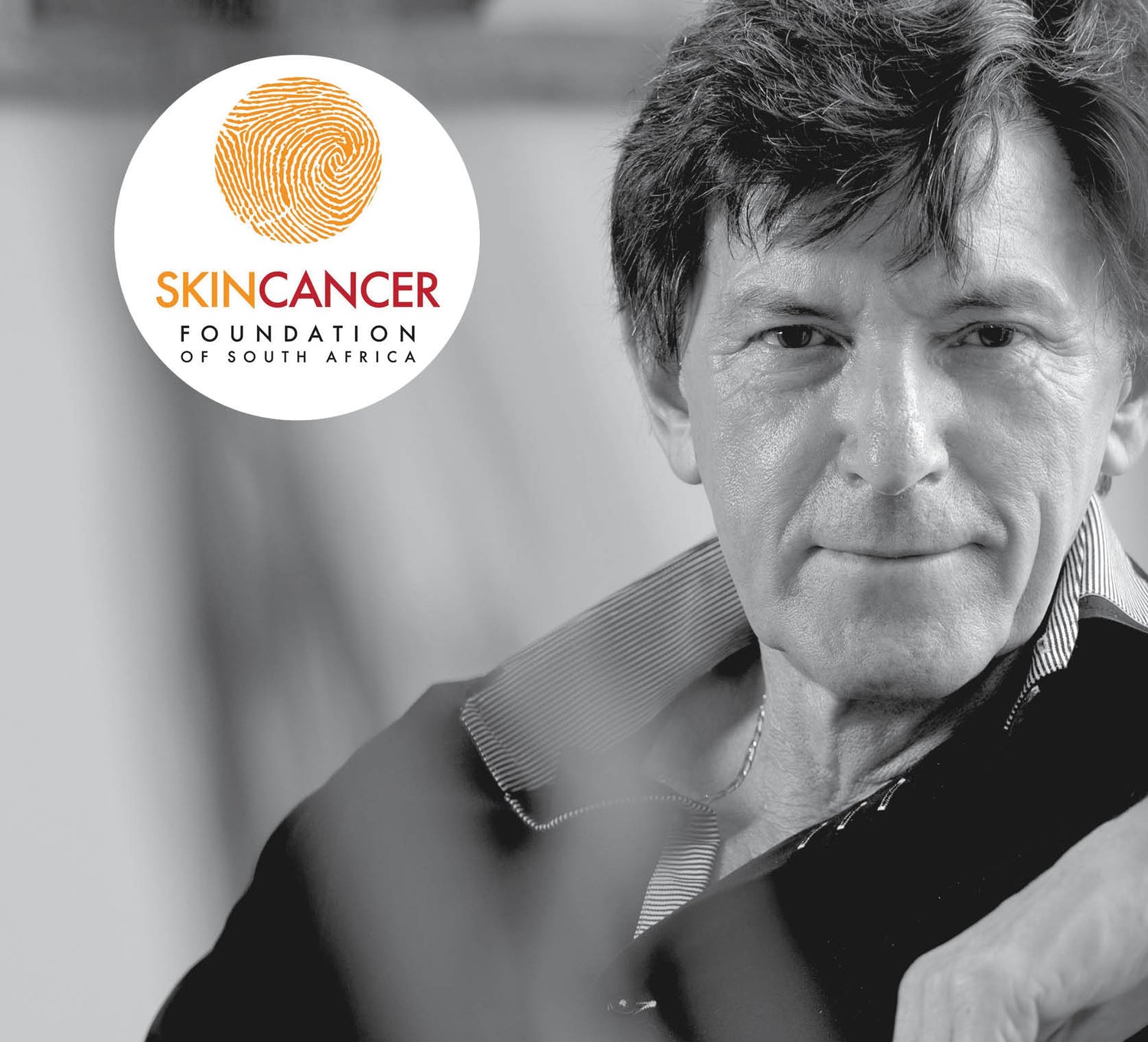 A circular logo featuring a golden fingerprint design above the text ’skincancer foundation of south africa’ in orange and black lettering.