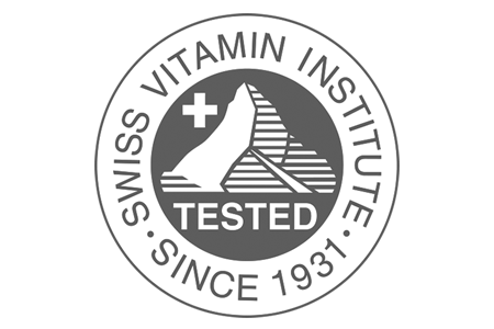 Swiss vitamin institute-tested circular logo featuring a white cross and mountain silhouette on a dark gray background.