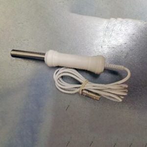 A laboratory temperature probe with a white handle and a stainless steel tip sits on a grey surface with its coiled cord.