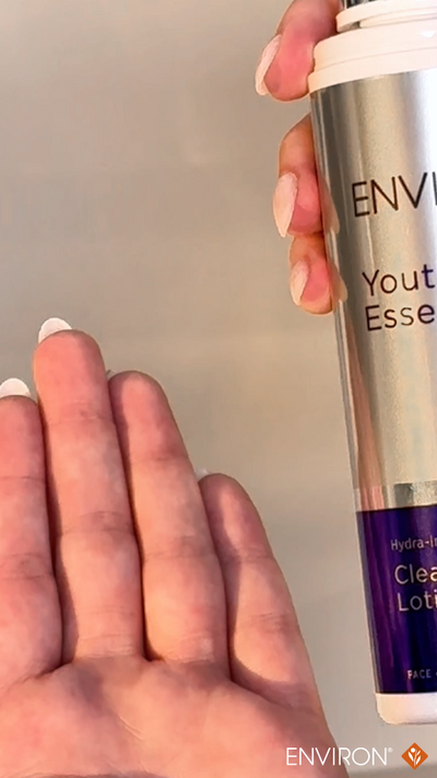 Silver and purple cylindrical bottle of environ youth essence clear lotion.