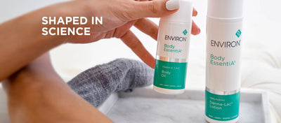 White cylindrical bottle with teal label and silver accent band, featuring ’environ body essentia’ branding