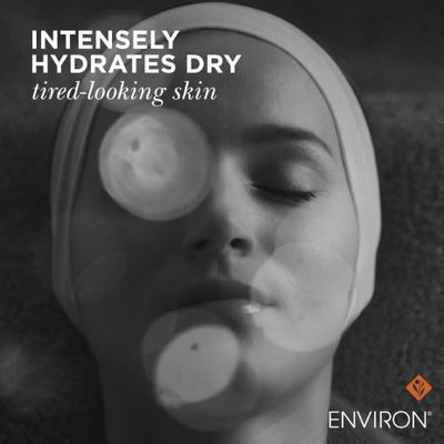 Black and white image of a woman wearing an environ eye mask over her eyes, with circular patches visible on the skin around them.