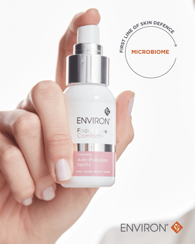 A sleek white and silver spray bottle of environ focus & comfort+ complete anti-pollution spritz, featuring a minimalist design with pink accents on the label.