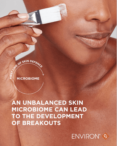 White and silver facial brush with a soft bristle head being used on skin.