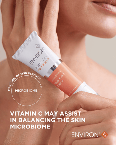 A white and peach-colored tube of environ focus care radiance+ melan-even cream with a silver cap.