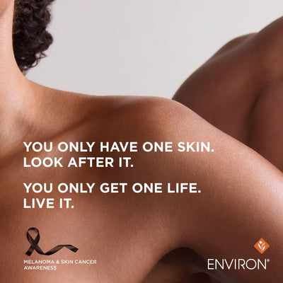 A black ribbon tattoo on a person’s shoulder, designed as an awareness symbol for melanoma and skin cancer.