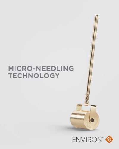 Gold-colored micro-needling roller with a sleek, cylindrical handle and textured rolling head.