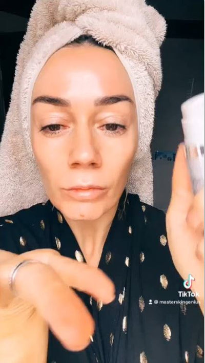 White cylindrical skincare jar with a matching lid, held in hand.