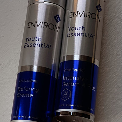 Two sleek silver and blue environ youth essentia skincare products, featuring metallic caps and bold branding.