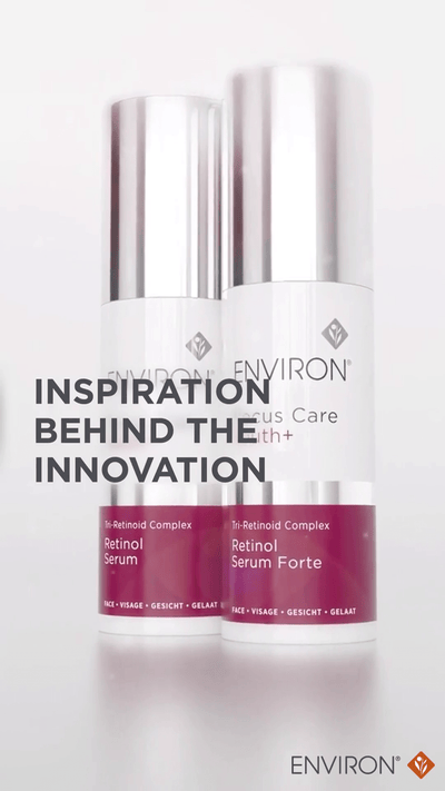 Two sleek, silver-topped bottles of environ skincare serum with white bodies and deep magenta labels.